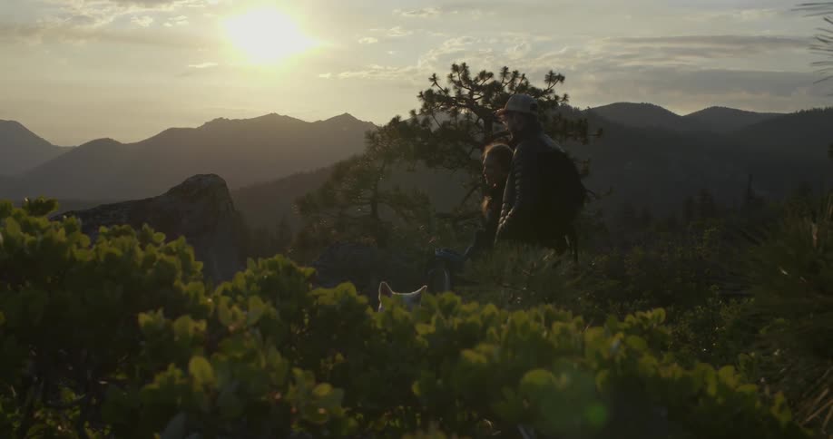 Two people stand in a field at sunrise