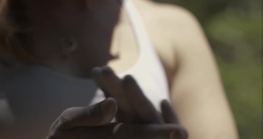 Woman rubbing chalk on her hands while wearing a tank top