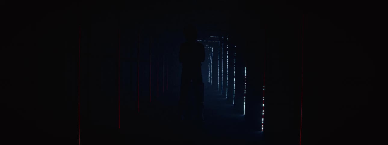 A motocross rider is dramatically revealed by strobing lights in a futuristic, smoky corridor