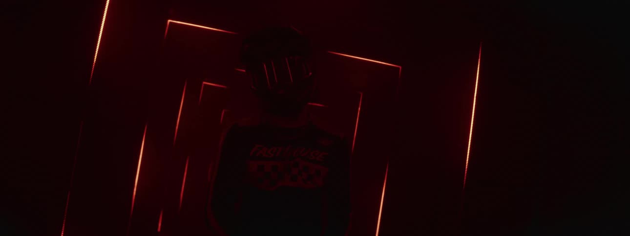 A futuristic portrait of a motocross rider in a dark tunnel illuminated by strobing red neon lights