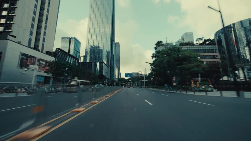 A cinematic point-of-view drive through the modern streets of a bustling city, surrounded by towering skyscrapers