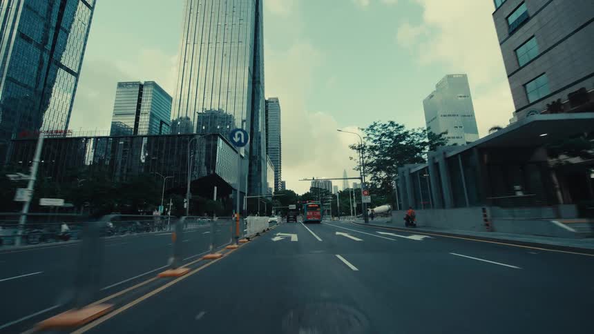 A cinematic point-of-view drive through the modern streets of a bustling city, surrounded by towering skyscrapers
