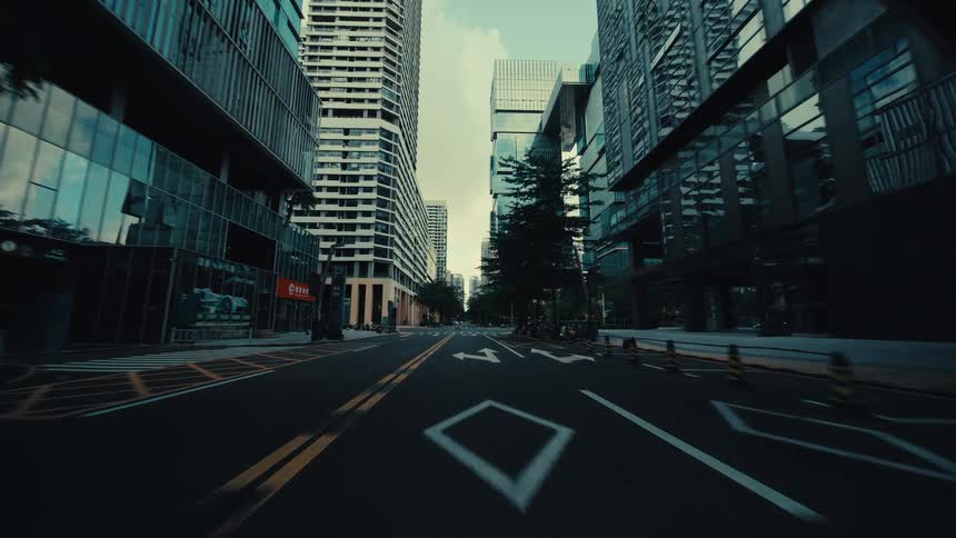 A cinematic forward dolly shot through an empty, modern city street surrounded by towering skyscrapers and unique architecture