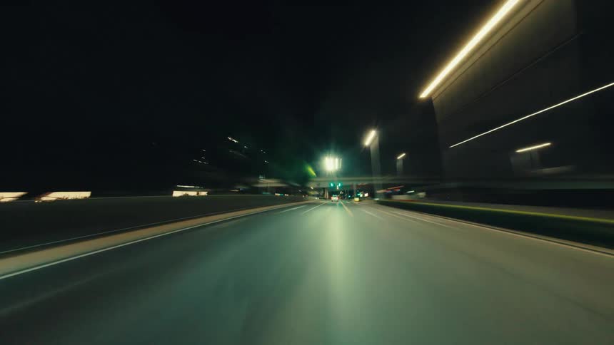 Futuristic POV hyperlapse shows a high-speed journey through a modern city at night with mesmerizing light trails