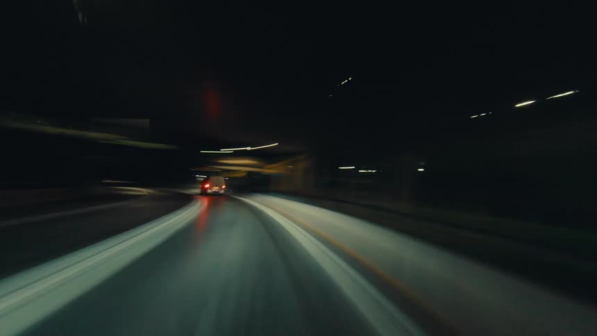 A futuristic POV hyperlapse of a high-speed drive through city highways and tunnels at night, creating mesmerizing light trails