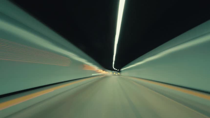 An exhilarating POV time-lapse speeds through a futuristic urban tunnel at night, with lights blurring into streaks of motion