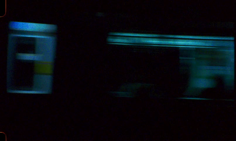 Vintage 8mm film captures the blur of a subway train speeding through the city at night