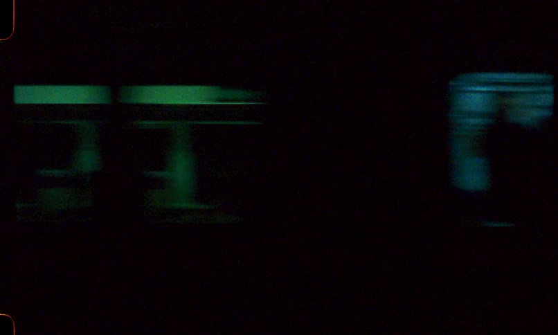 An abstract, vintage film shot captures the motion blur of a passing subway train at night