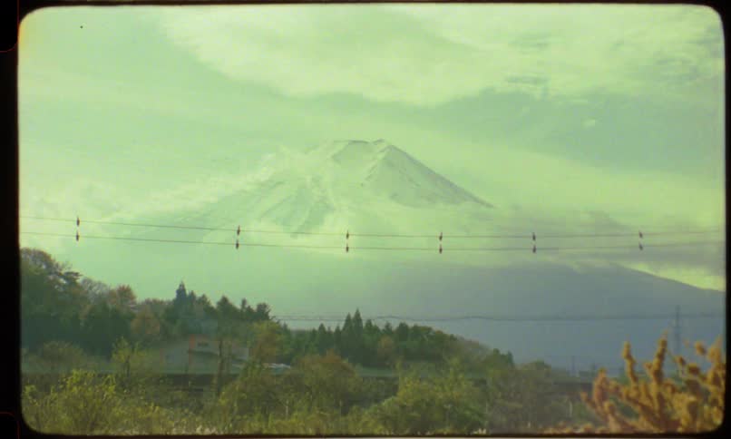 Archival footage captures a scenic view of Japan's snow-capped Mount Fuji from a moving vehicle