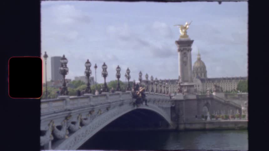 Authentic vintage film footage captures a classic view of the ornate Pont Alexandre III bridge over the Seine river in Paris, France