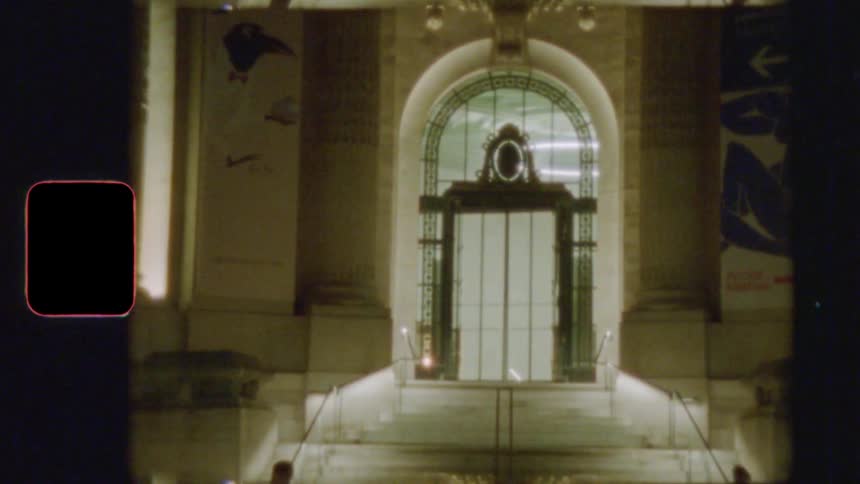 Vintage Super 8 film of a grand Parisian museum entrance illuminated at night