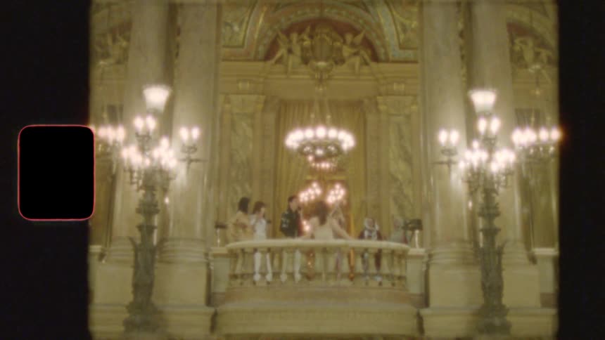 Vintage 8mm footage of a stylish group of people posing on a grand balcony in an opulent opera house