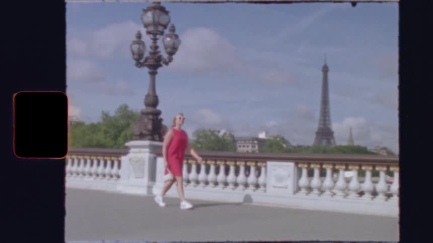 Vintage 8mm footage shows a woman in a red dress walking across the Pont Alexandre III bridge in Paris, France with the Eiffel Tower in the background