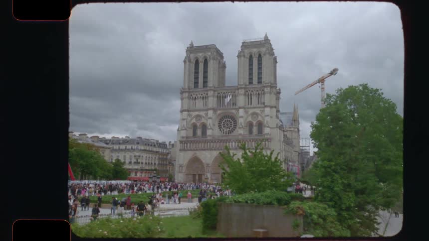 A nostalgic tracking shot on vintage film reveals the famous Notre-Dame Cathedral in Paris, with crowds gathered in the square on an overcast day