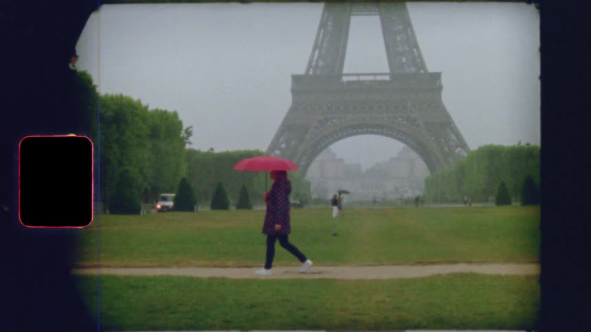 Vintage film footage shows a woman with a red umbrella walking in slow motion through a rainy park with the Eiffel Tower in the background