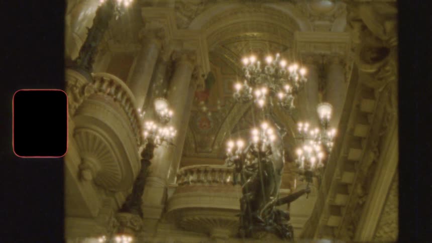 Vintage film slowly reveals the magnificent baroque interior of a grand opera house, highlighting its ornate balconies and glowing chandeliers