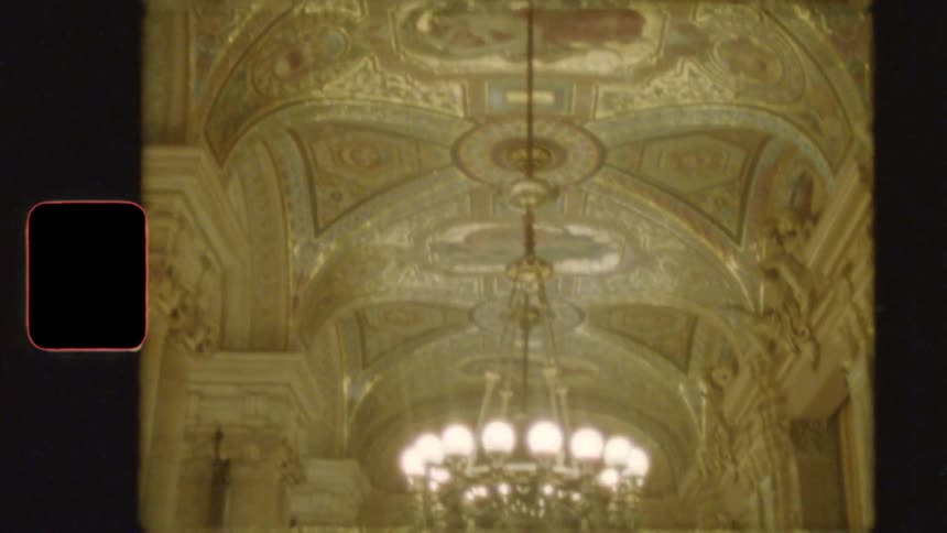 Ornate painted ceilings and dazzling chandeliers of a grand historic hall are revealed in this vintage film footage