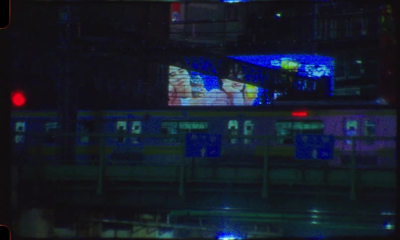 Vintage-style footage of a train passing through the neon-drenched city of Tokyo at night