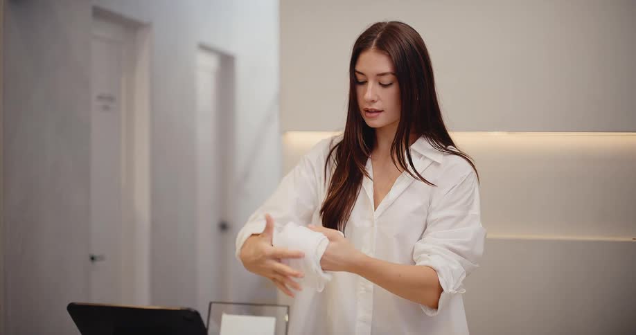 Slow motion shot of a retail employee carefully folding a white shirt to be packaged for a customer