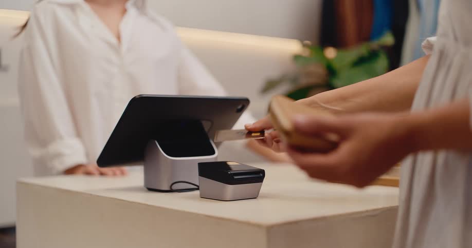 Close up of a customer inserting her credit card into a payment terminal at a modern retail store checkout