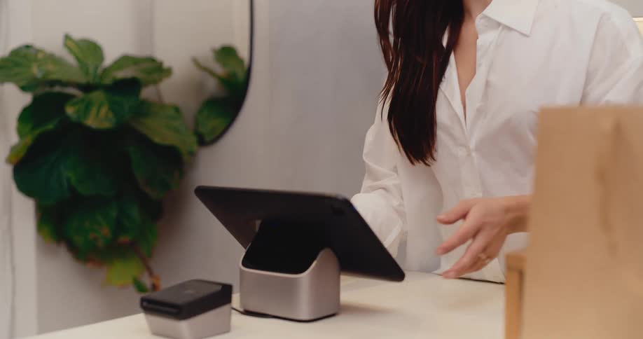 A retail assistant assists a customer with a purchase, culminating in a smooth contactless credit card payment at the POS terminal