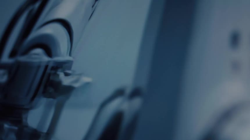 Close-up detail of a white robotic arm joint moving in a futuristic, sterile laboratory