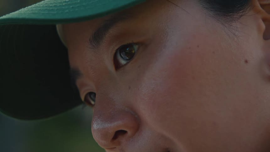 Close-up of a young woman's face, panning from her ear piercing to her introspective eyes