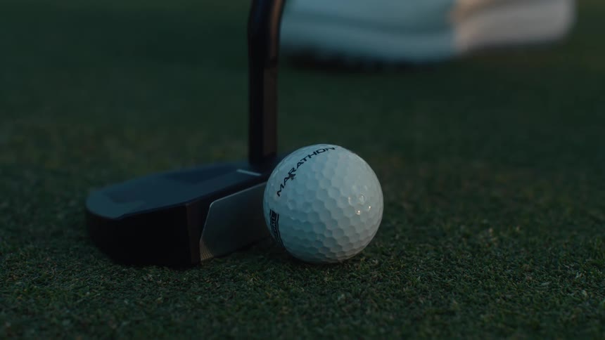 A close-up shot shows a golfer lining up a putt and then striking the golf ball on the putting green