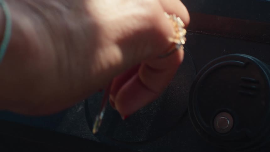 A close-up shot shows a hand inserting a key into an ignition and turning it to the on position