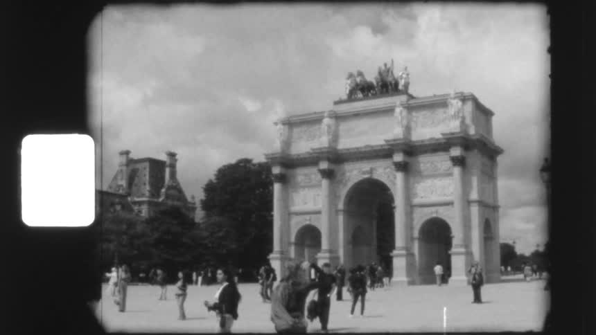 Vintage black and white 8mm film captures tourists visiting the Arc de Triomphe du Carrousel in Paris