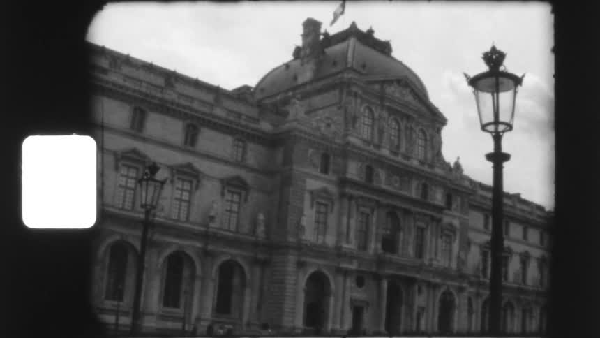 Vintage 8mm footage reveals a low-angle view of the Louvre Museum in Paris on a cloudy day