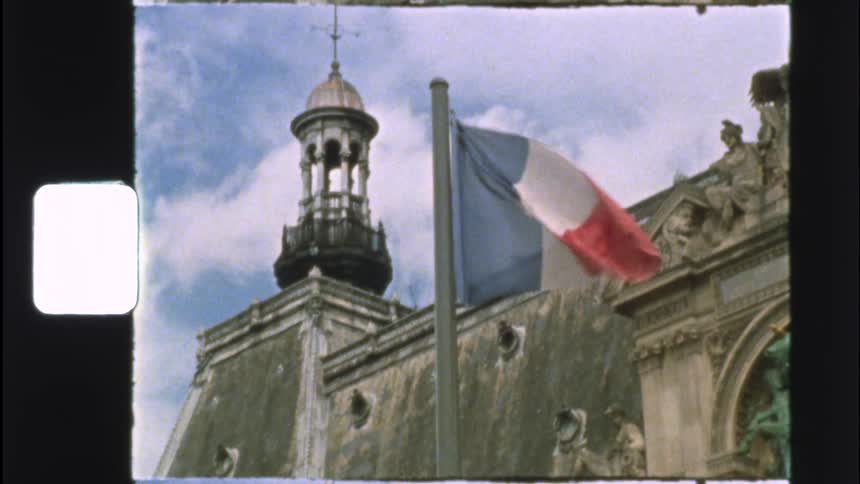 Vintage 8mm footage shows the French flag waving in slow motion in front of a historic building in Paris