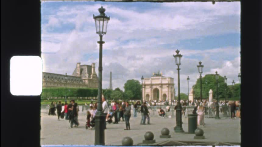 Vintage film captures tourists enjoying a sunny day at the Arc de Triomphe du Carrousel in Paris, France