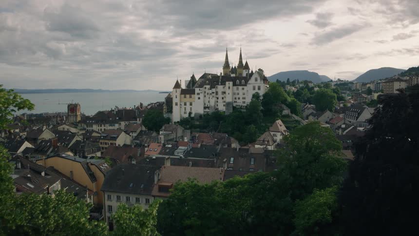 An aerial view reveals the majestic Neuchâtel Castle overlooking the historic old town and lake in Switzerland