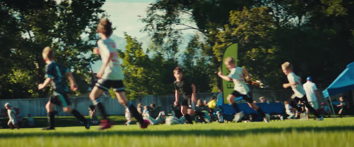Energetic young soccer players race down the grassy field in a dynamic slow-motion shot