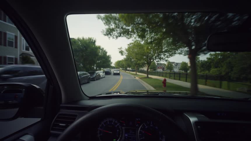 A serene drive from the driver's perspective through a quiet, well-kept suburban American neighborhood