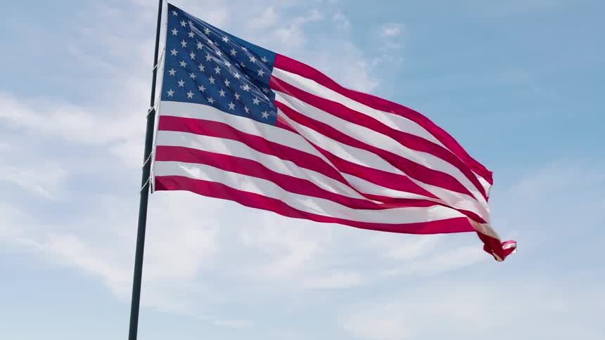 Counter clockwise orbit around the American flag waving proudly against a painted sky