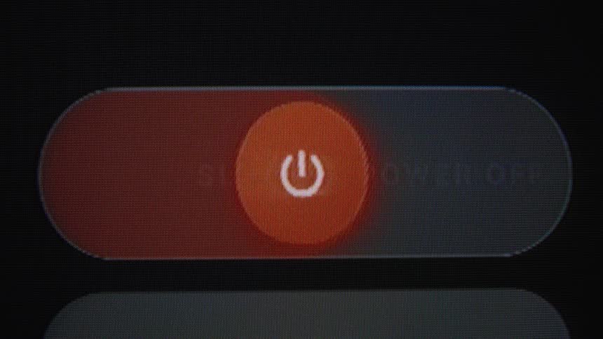 A macro close-up of the 'slide to power off' graphic being activated on an electronic device screen