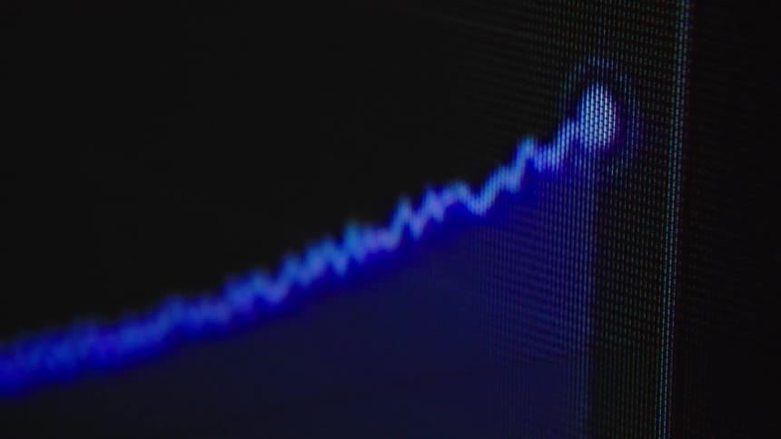 Macro shot of a blue digital audio waveform or histogram graph being generated on a computer screen