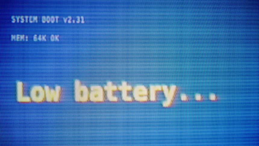 A retro computer screen displays a low battery warning before flickering and shutting down