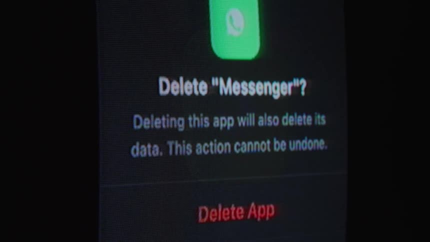 A user permanently deletes the WhatsApp messenger app and all its data from a smartphone