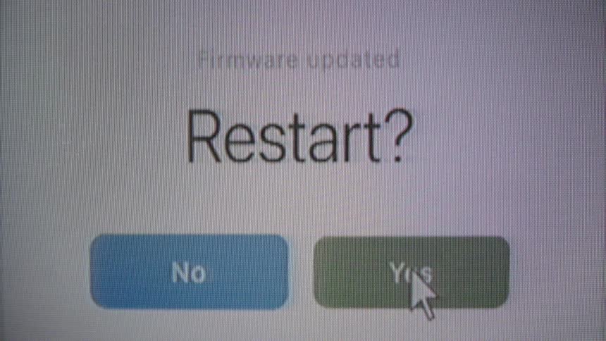 A close-up of a computer screen shows a user clicking 'Yes' to restart the system after a firmware update, followed by a progress bar and a 'Done' confirmation message