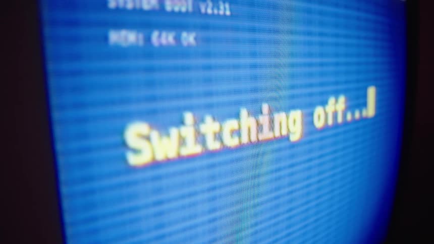 A vintage computer with a blue screen displays the message 'Switching off...' before glitching and powering down