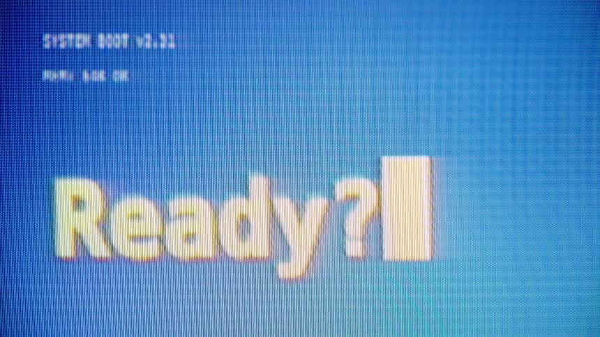 A retro computer screen with a blue background displays a 'Ready?' prompt with a blinking cursor