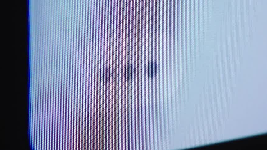 A close-up macro shot of a pulsating three-dot loading or typing icon on a digital screen, showing the individual pixels