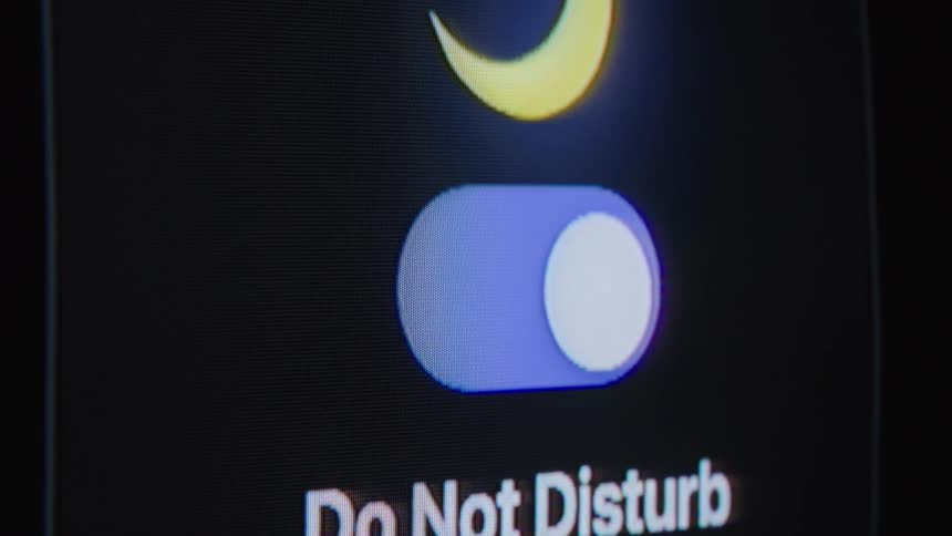 Close-up macro shot of the 'Do Not Disturb' feature being activated on a smartphone screen to silence notifications
