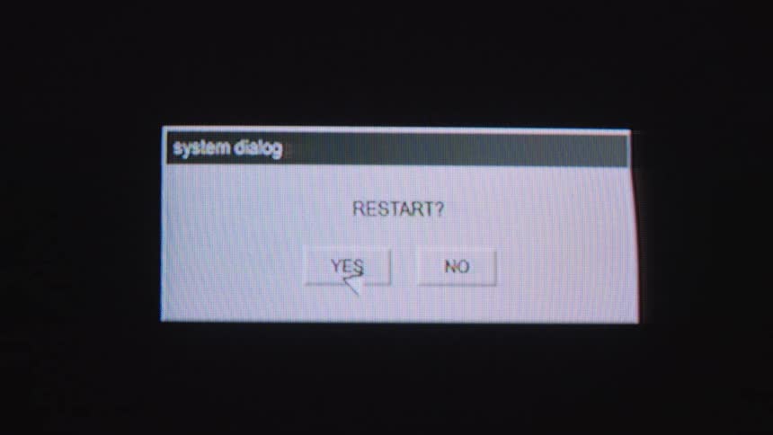 A retro computer screen shows a system restart sequence, starting with a dialog box, a progress bar, and ending with 'System Ready'