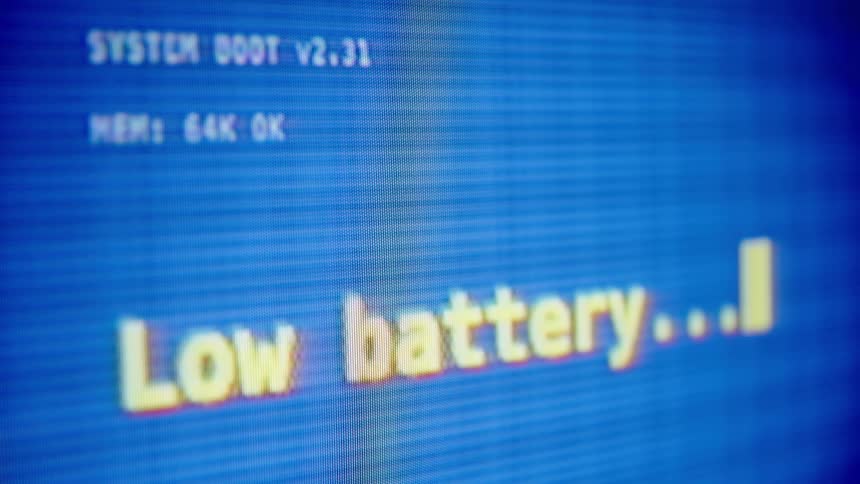 Close-up of a retro computer screen showing a "Low battery" warning during system boot
