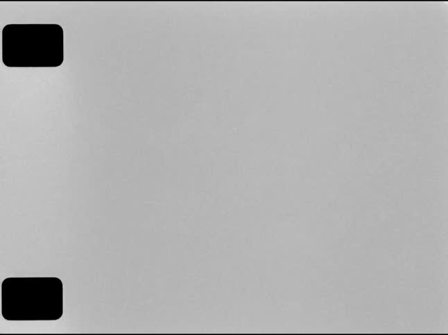An authentic 16mm film leader effect with sprocket holes, dust, grain, and scratches in black and white