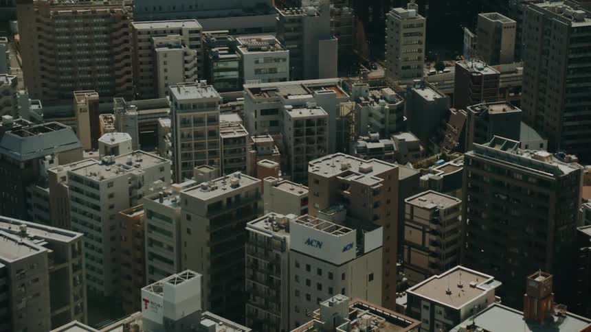 Simulated earthquake effect shakes an aerial view of a dense city skyline in Tokyo